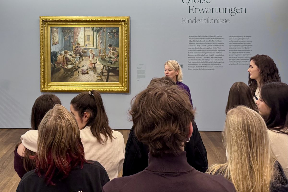 Gruppe von Schülern mit Museumsführerin vor einem Gemälde des Impressionismus