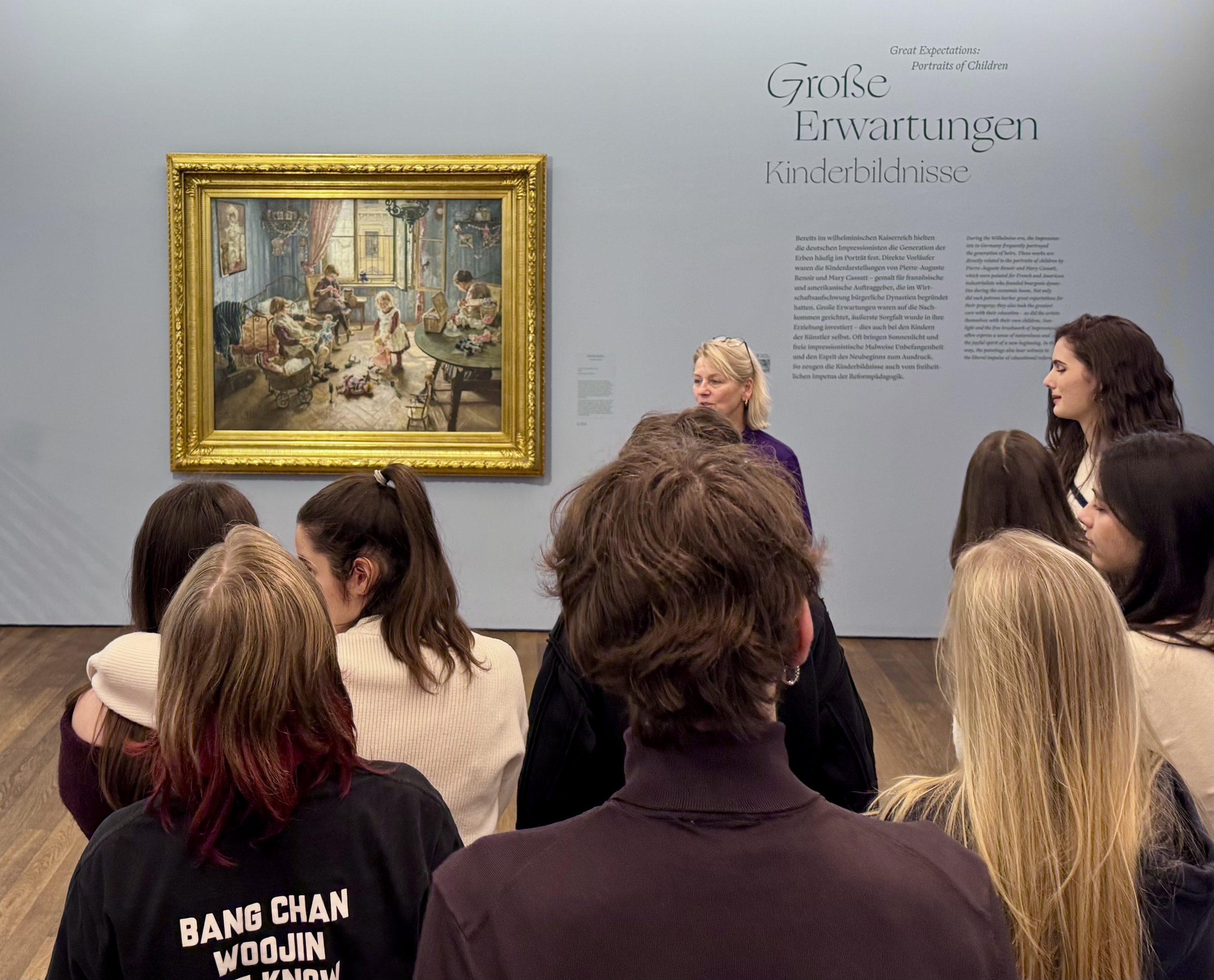 Gruppe von Schülern mit Museumsführerin vor einem Gemälde des Impressionismus