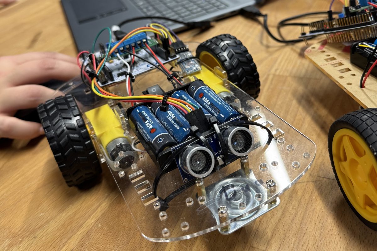 Programmiertes kleines Fahrzeug mit sichbarer Technik in Form von Kabeln und Batterien
