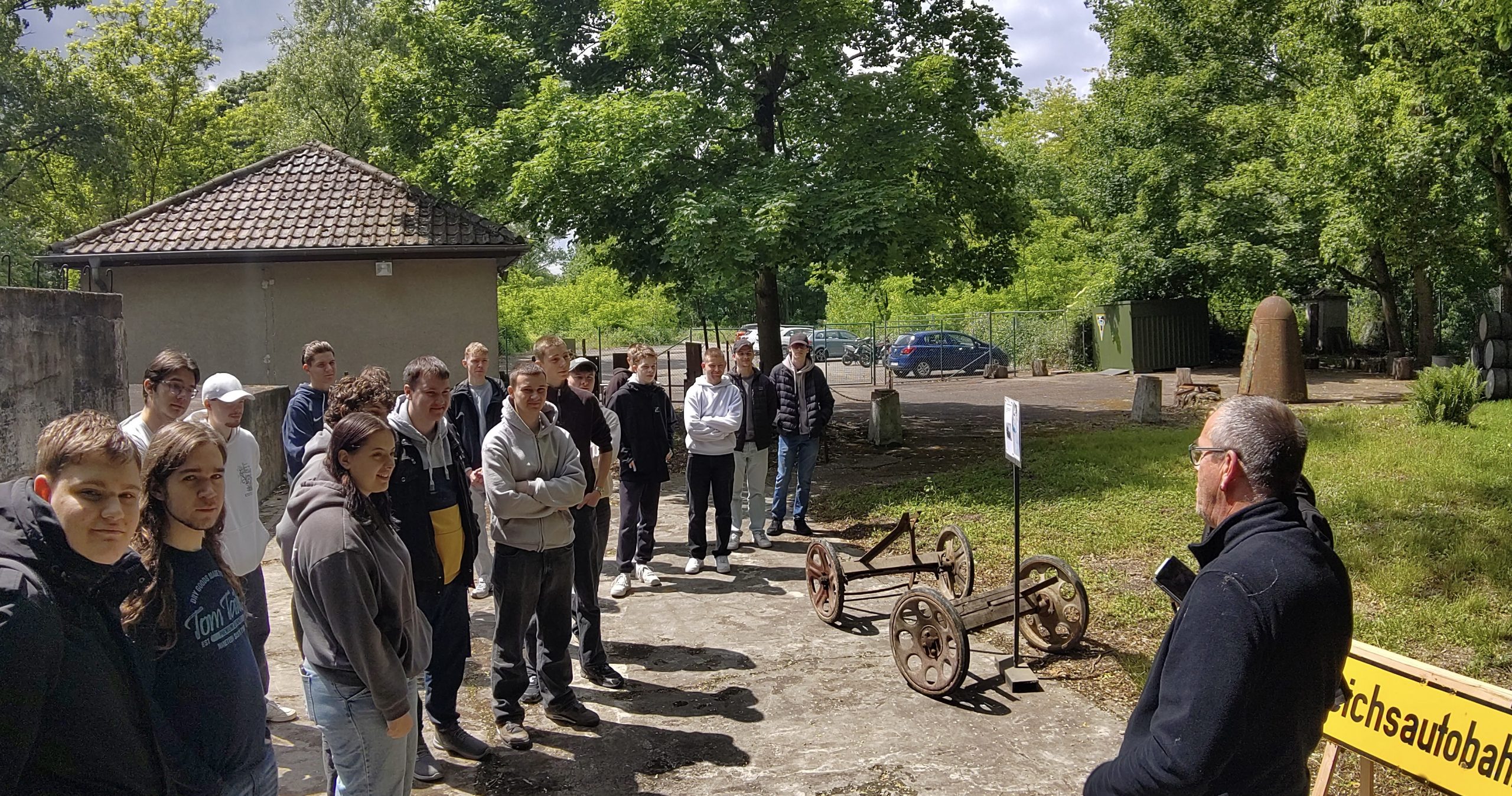 Schülergruppe im Außenbereich vor einem Bunker