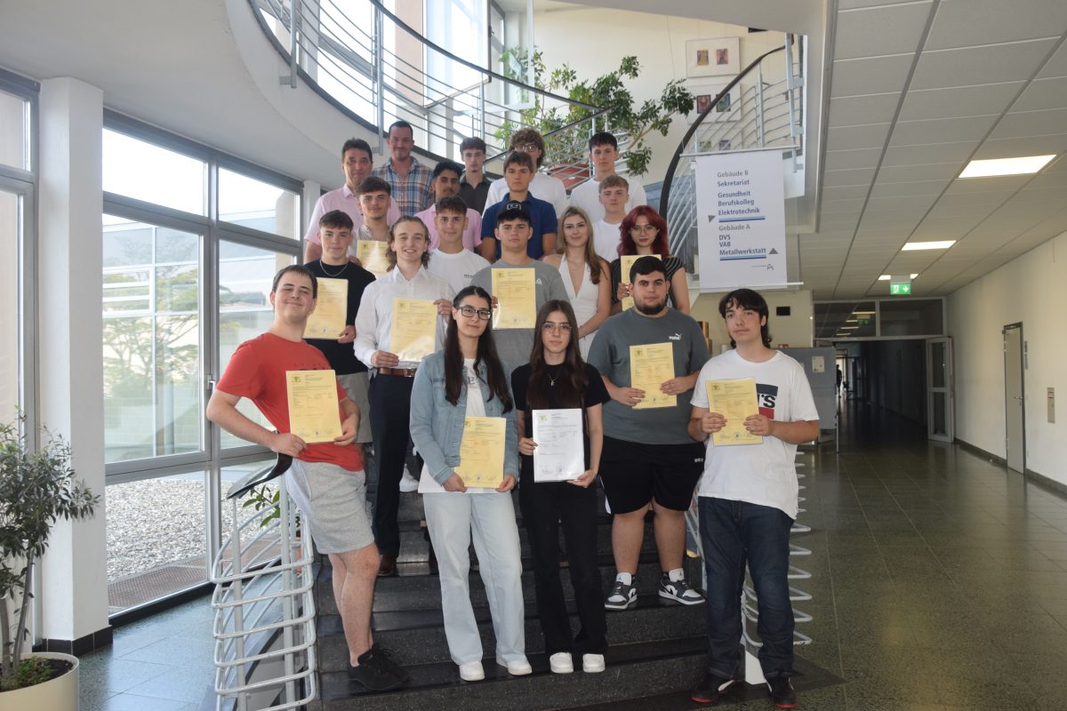 Abschlussklasse des Technischen Berufskolleg 2 auf der der geschwungenen Treppe im Schulflur