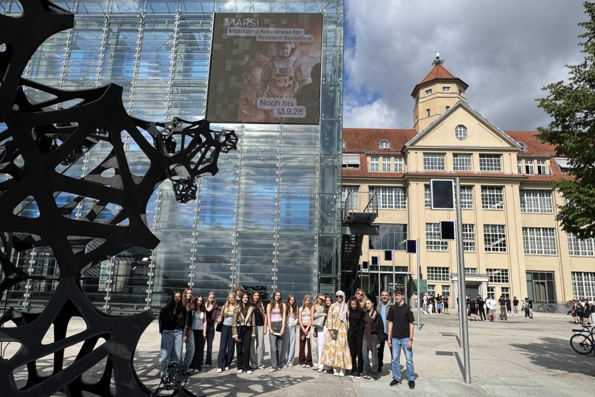 Schulklasse im Vordergrund des ZKM-Gebäudes mit dem blauen Kubus links und dem Eingang rechts