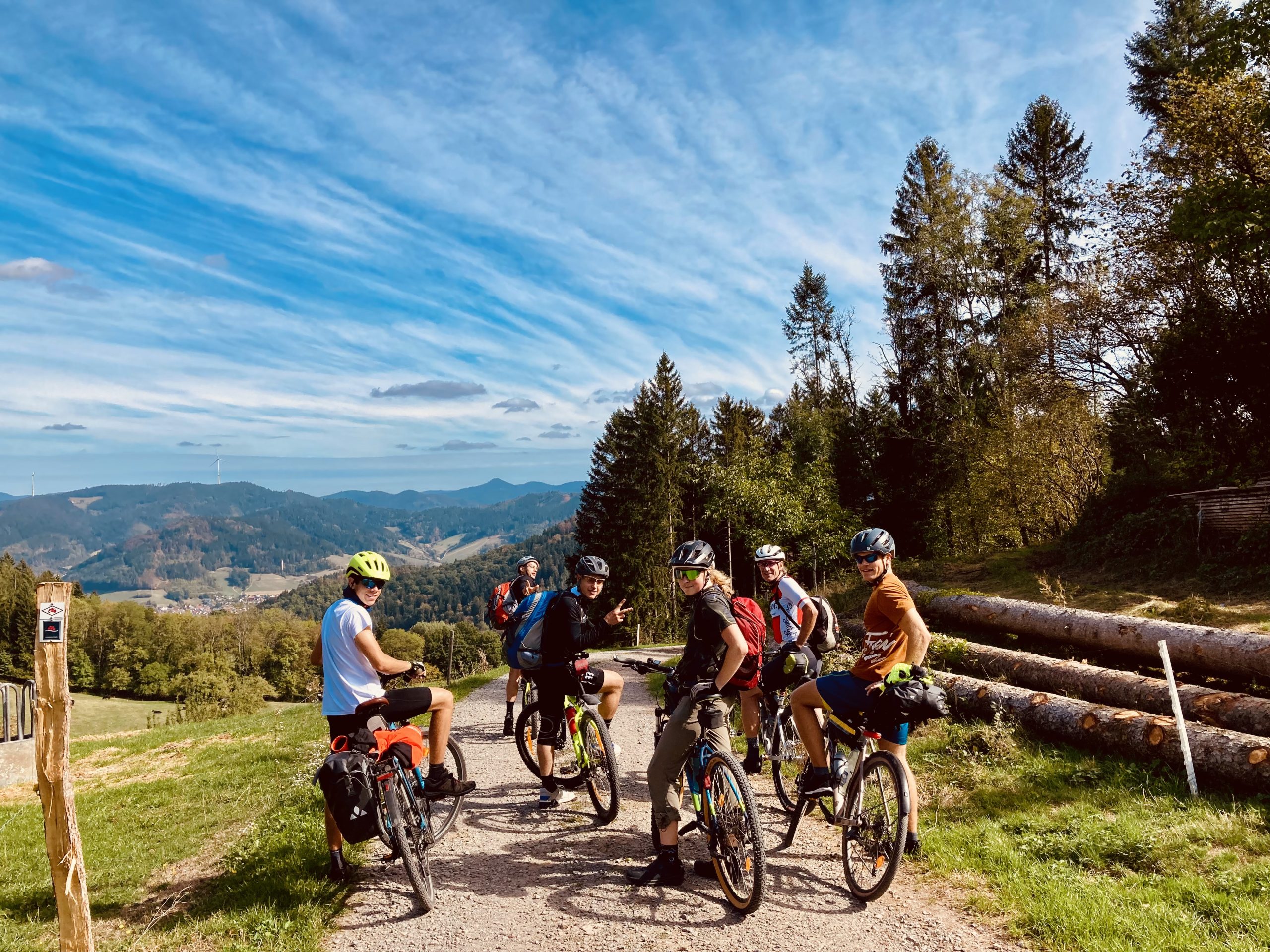 Eine Gruppe von Mountainbikern steht auf einem Weg in der Landschaft.